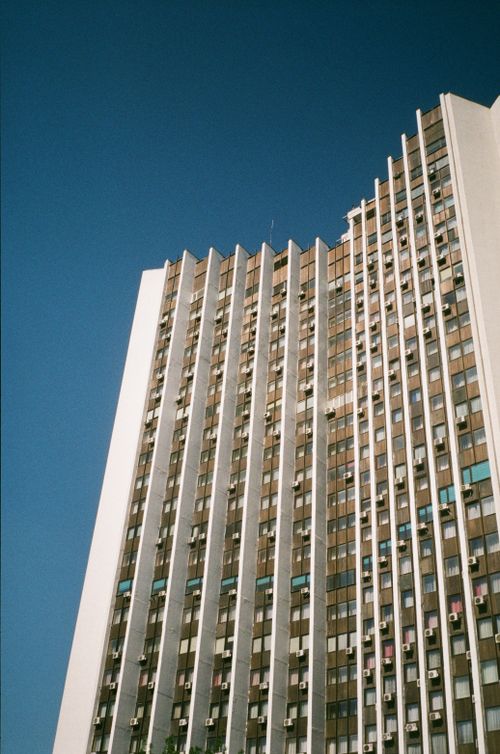 Free Tall skyscraper in Kyiv, Ukraine, showcasing modern architecture against a clear blue sky. Stock Photo