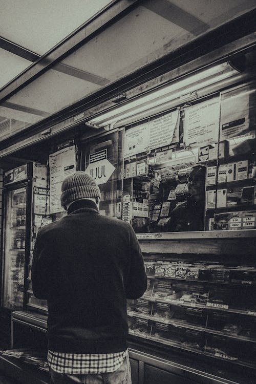 Grayscale Photo of a Man Buying on a Store