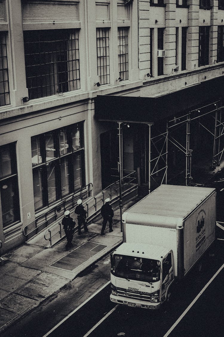 Grayscale Photo Of A Truck On Road