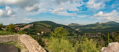 Free Explore a picturesque hillside town surrounded by lush greenery under a bright blue sky. Stock Photo
