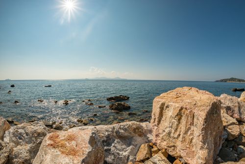 Gratis Bellissima costa rocciosa sotto un cielo blu brillante con vista chiara sull'oceano, ambientazione estiva. Foto a disposizione
