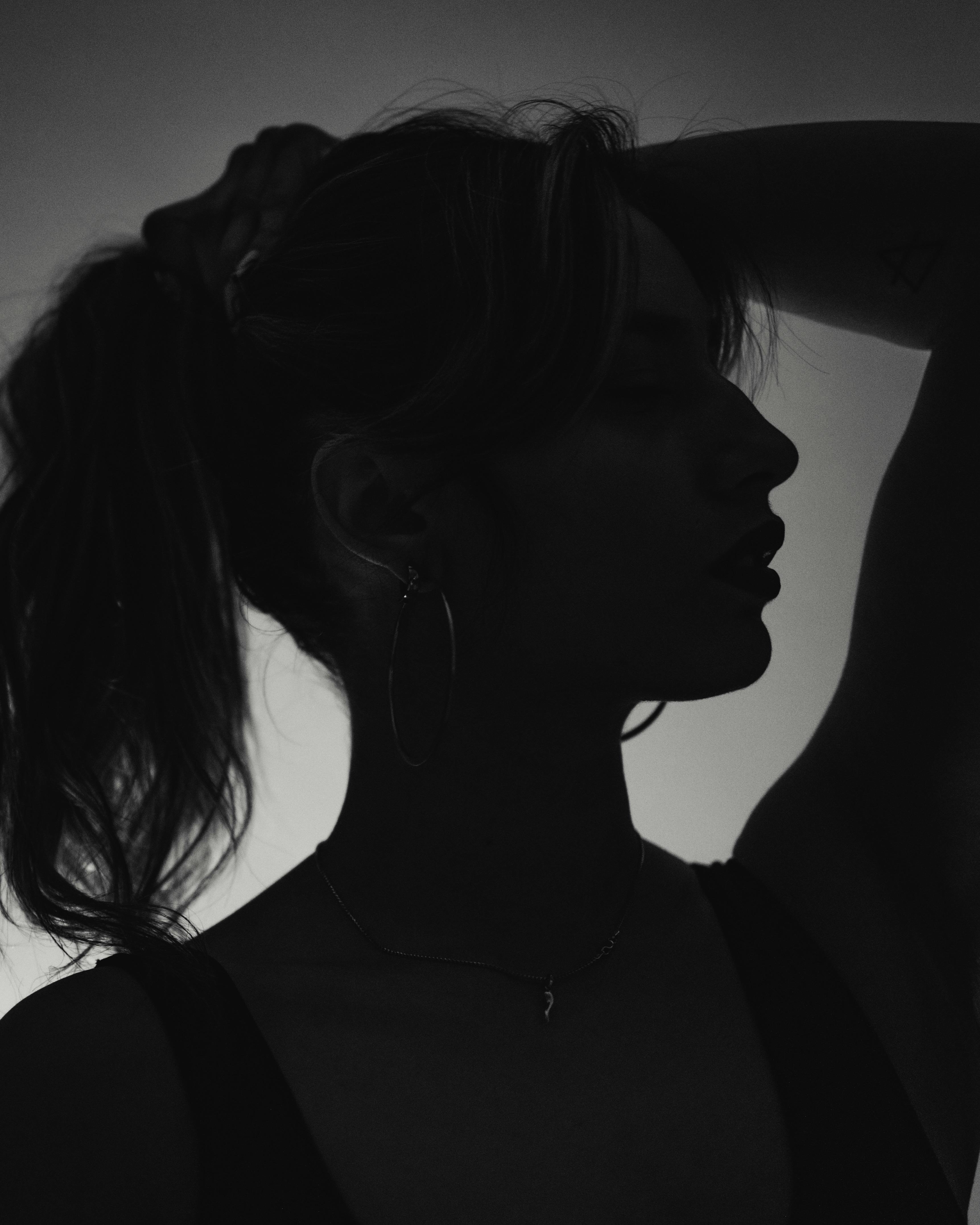 A striking black-and-white silhouette of a woman in a contemplative pose.