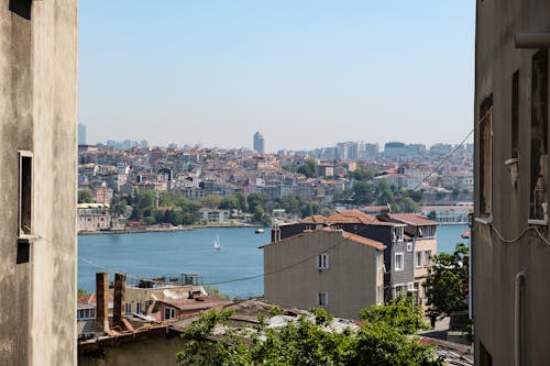 Boats Sailing on the River Between City Buildings 