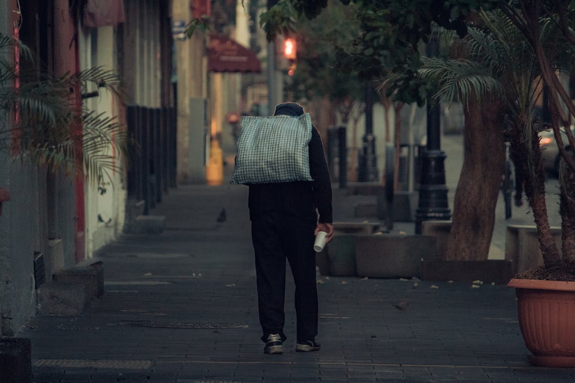 A Man Walking on the Sidewalk · Free Stock Photo