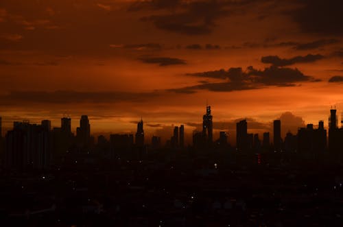 Silhouette of City Buildings Under Red Sky