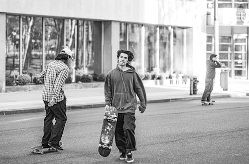 Grayscale Photo of Men Skateboarding
