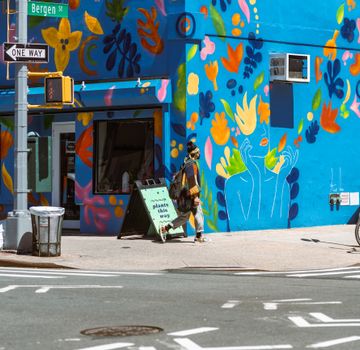 Woman walking by colorful building