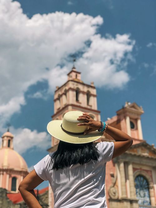 Free Back view of a tourist in a straw hat at the historic church in Tequisquiapan, Mexico. Stock Photo