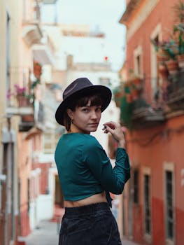 A fashionable woman poses in a vibrant Guanajuato alley, showcasing her unique style.