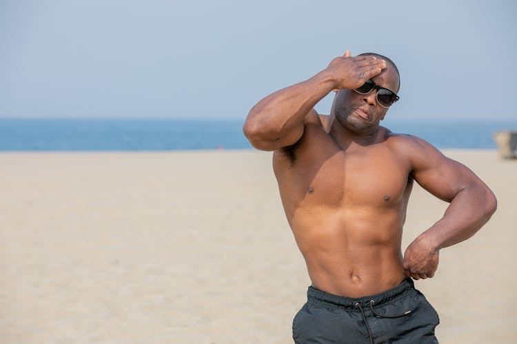 Shirtless Man With Athletic Build On The Beach In A Funny Pose