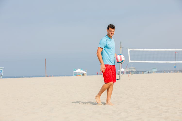 Young Man Getting Ready To Serve Ball On Beach