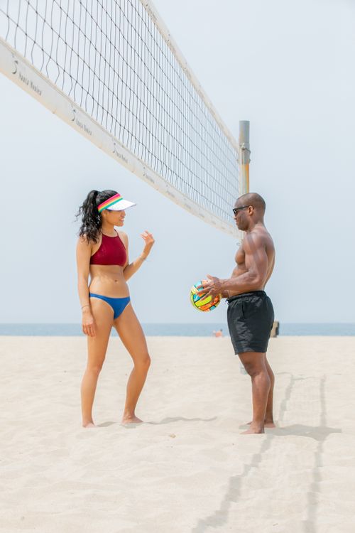 Free A man and woman discuss volleyball strategy on a sunny beach. Stock Photo