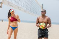 Man in Blue and Yellow Shorts Holding Yellow and Green Volleyball