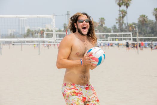 Man enjoying a lively game of beach volleyball on a sunny day by the ocean.