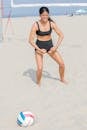 Woman in Black Sports Bra and Shorts Standing on White Sand
