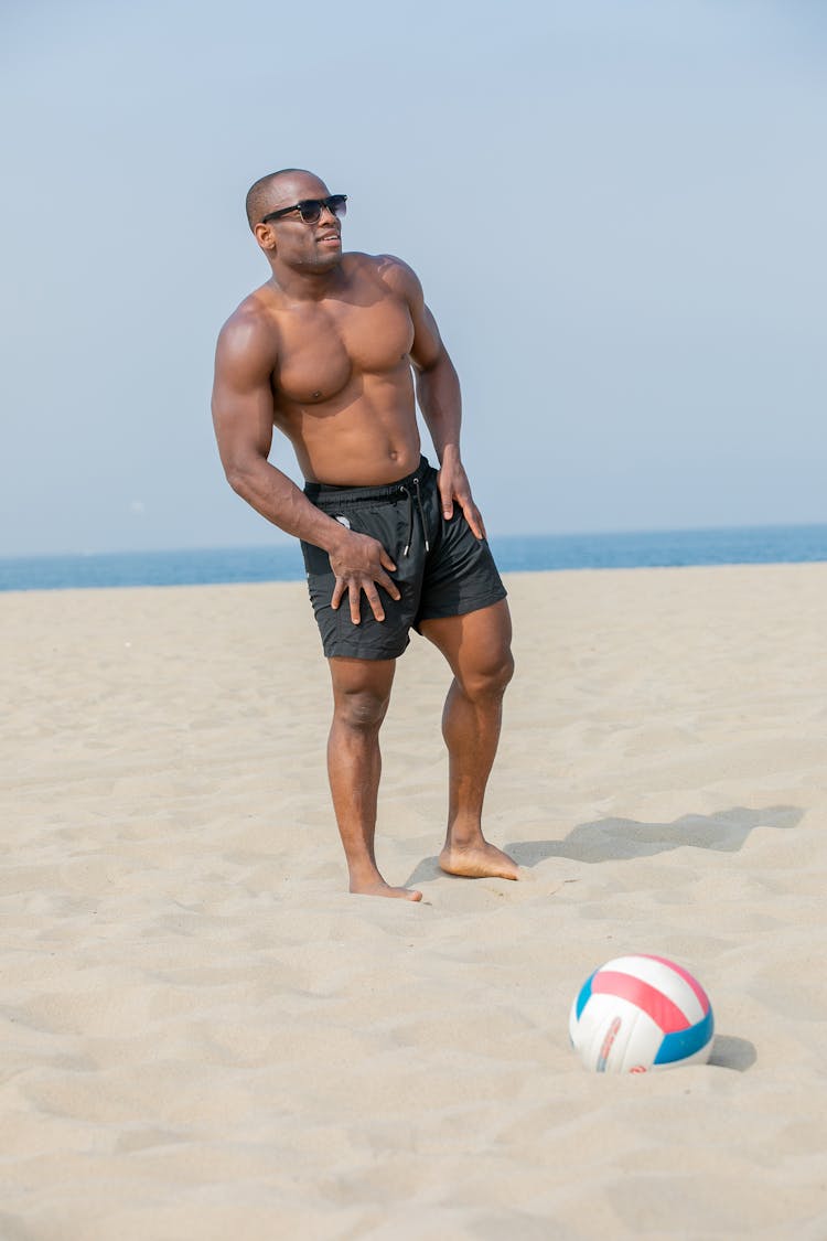 Athletic Young Man In Sunglasses Standing On Beach