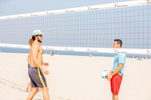 Free Two men enjoying a game of volleyball on a sunny beach, capturing the fun of summer. Stock Photo