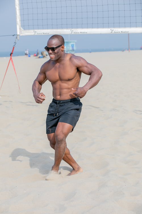 Shirtless Man with Athletic Build on the Beach in a Funny Pose · Free Stock  Photo