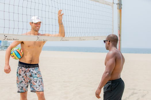 Two men enjoying a casual volleyball game on the sandy beach of Santa Monica.