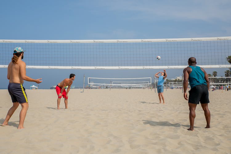 Friends Playing Volleyball On Beach