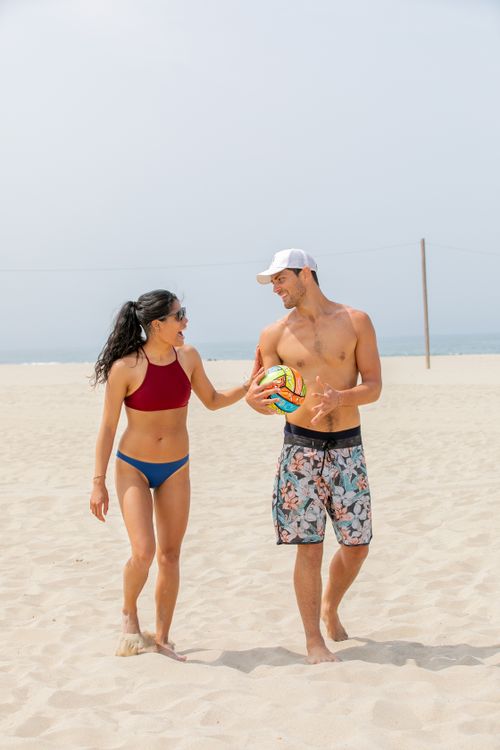 Free Young couple playing beach volleyball on a sunny day, enjoying summer vibes. Stock Photo