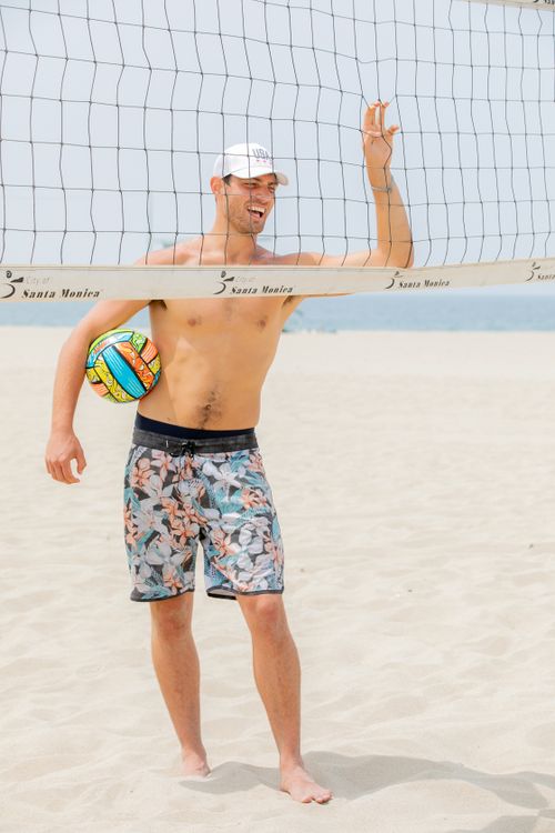 Free Shirtless man holding volleyball by the net at sunny Santa Monica Beach. Stock Photo