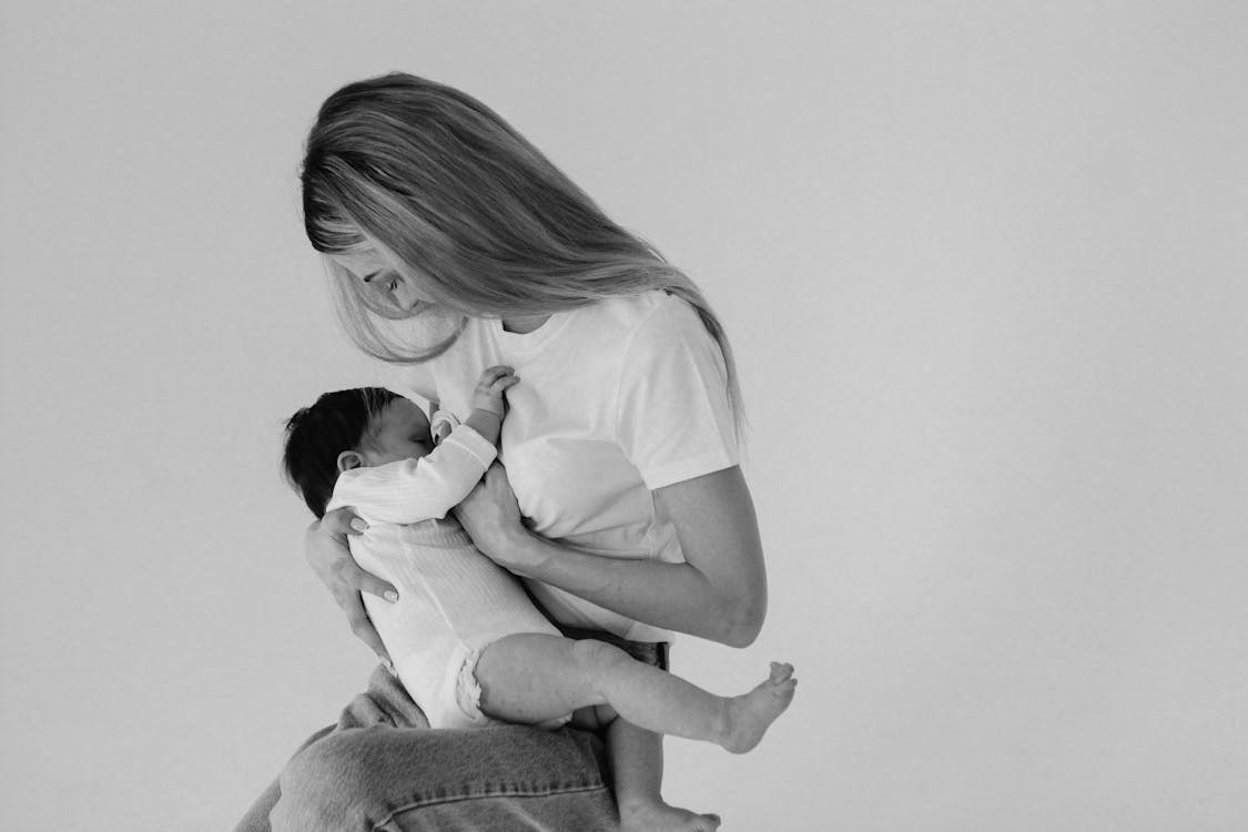 Free Grayscale Photo of a Mother Breastfeeding Her Child Stock Photo