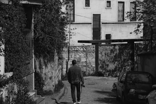 Free Grayscale Photo of a Person Walking on the Alley Stock Photo