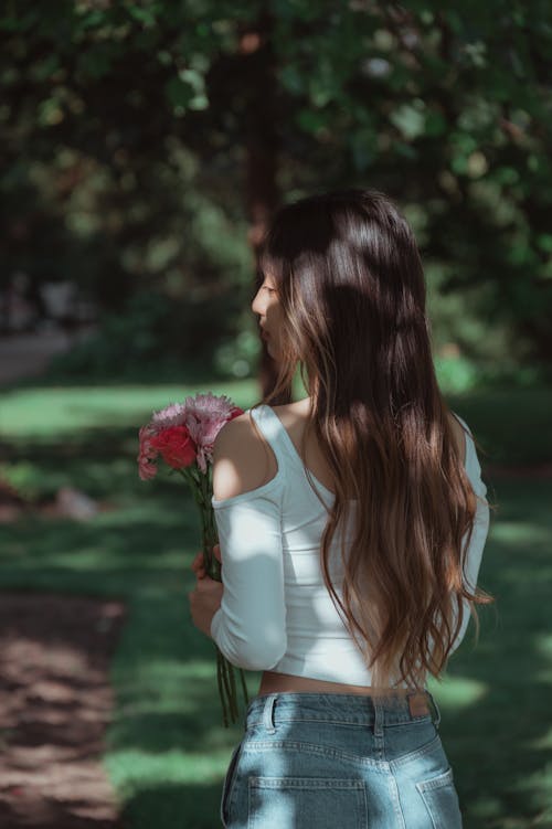 A Long Haired Woman Holding Flowers