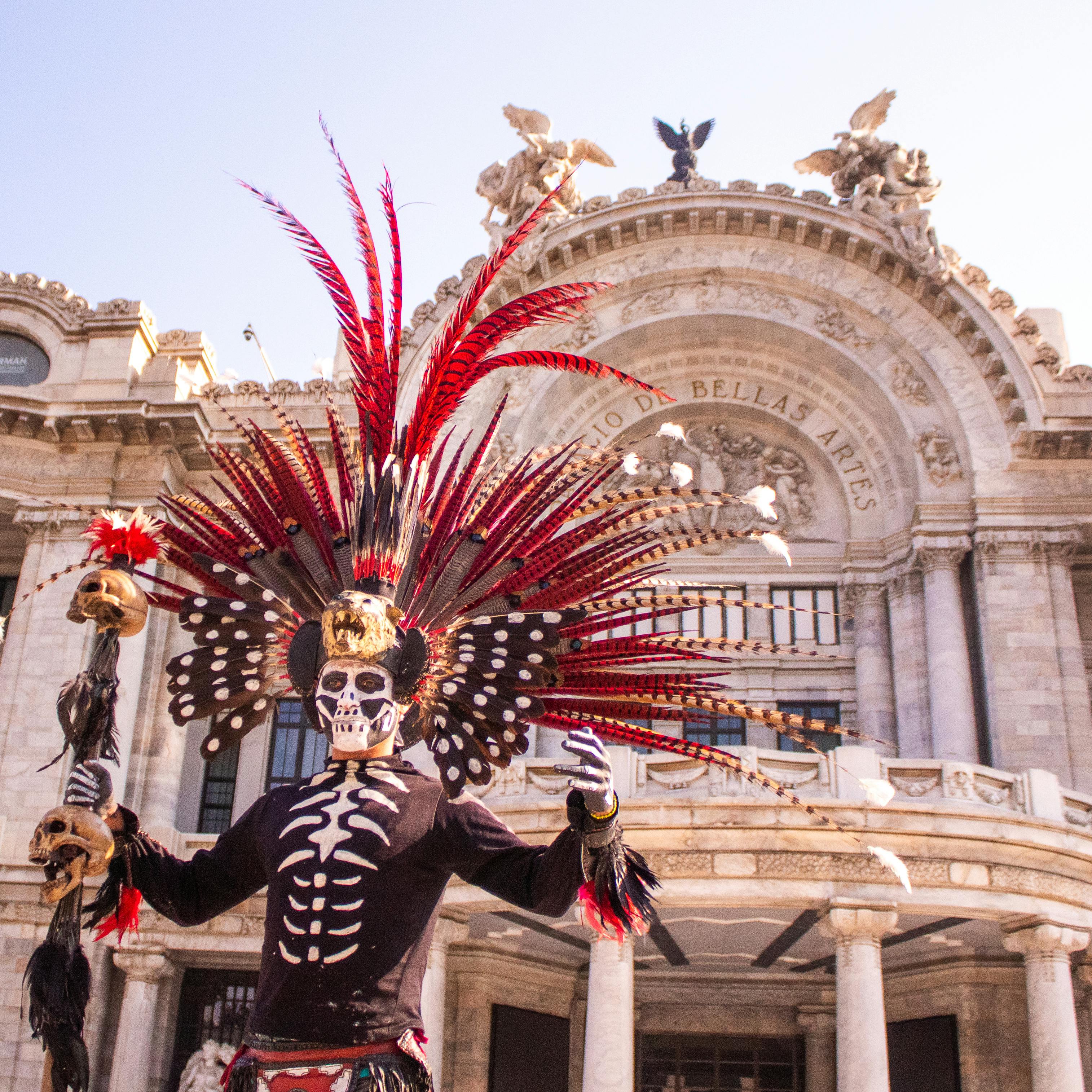 a man in halloween costume standing near palacio de bellas artes