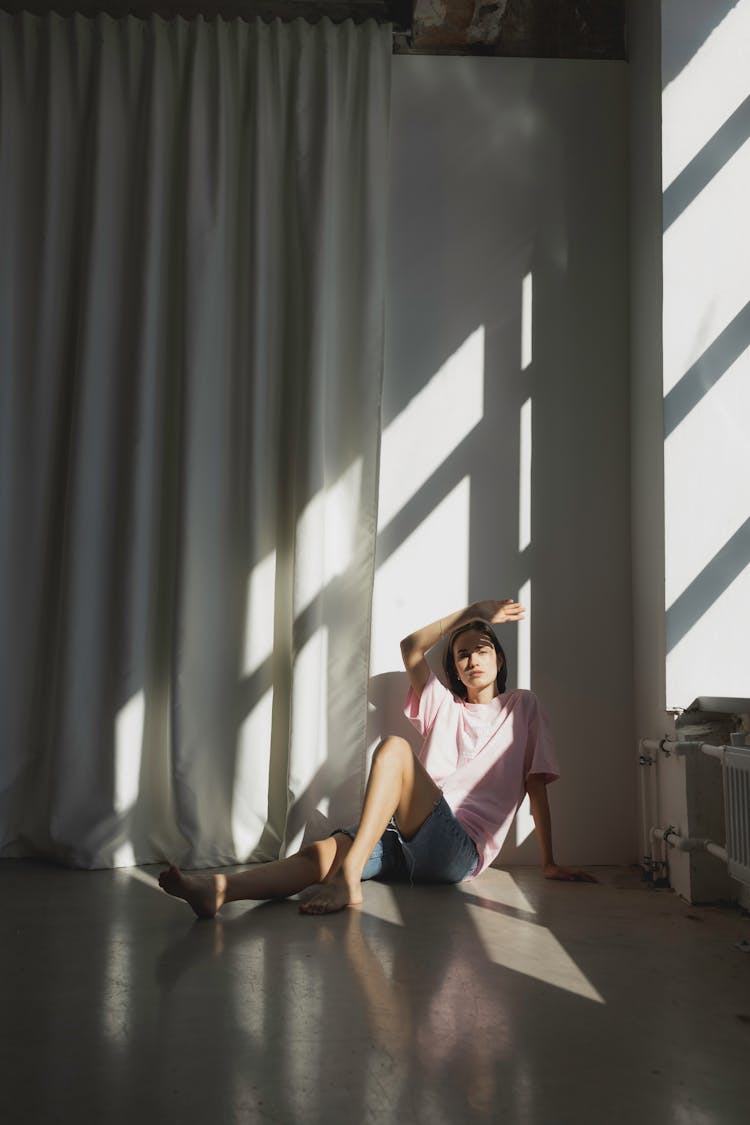 Woman In Pink T Shirt Sitting On The Floor