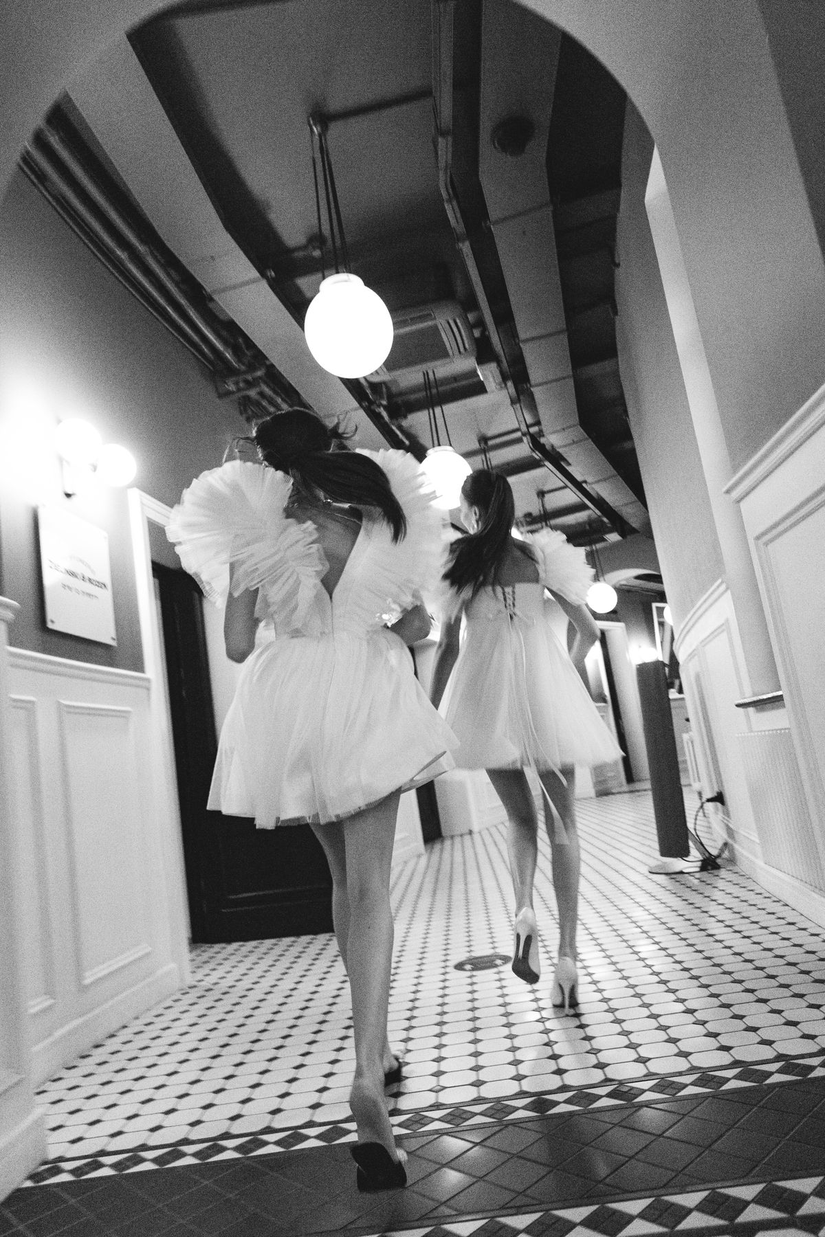 Two women in dramatic voluminous dresses in motion — the theatre of the ruffle