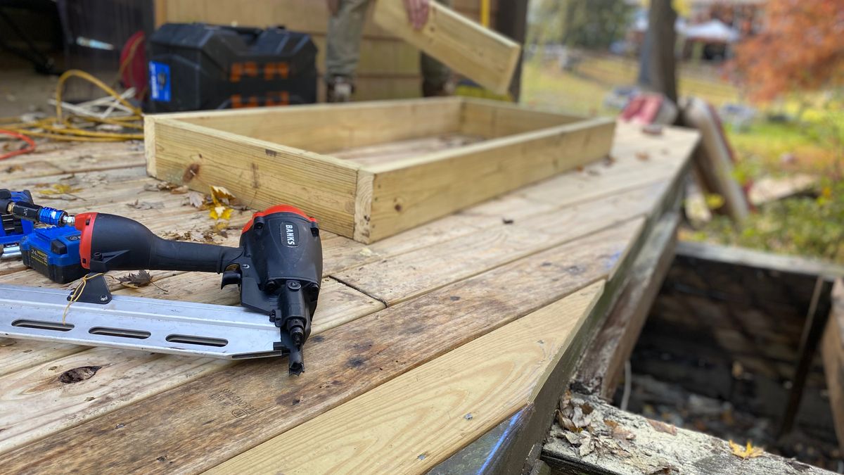 Fastening deck boards over the joists with a nail gun. Each board is fastened at every joist it crosses.
