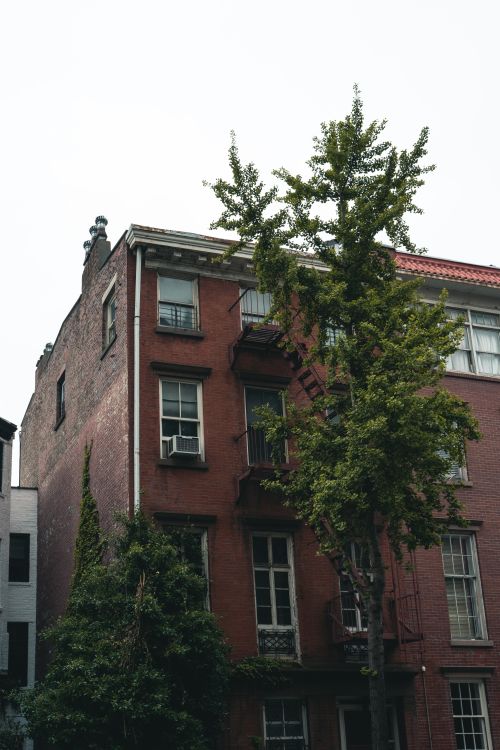 Free Charming red brick townhouse with greenery, showcasing urban residential architecture. Stock Photo