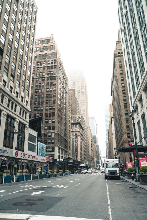 Free Street view of towering skyscrapers on a foggy day in New York City, showcasing urban architecture. Stock Photo