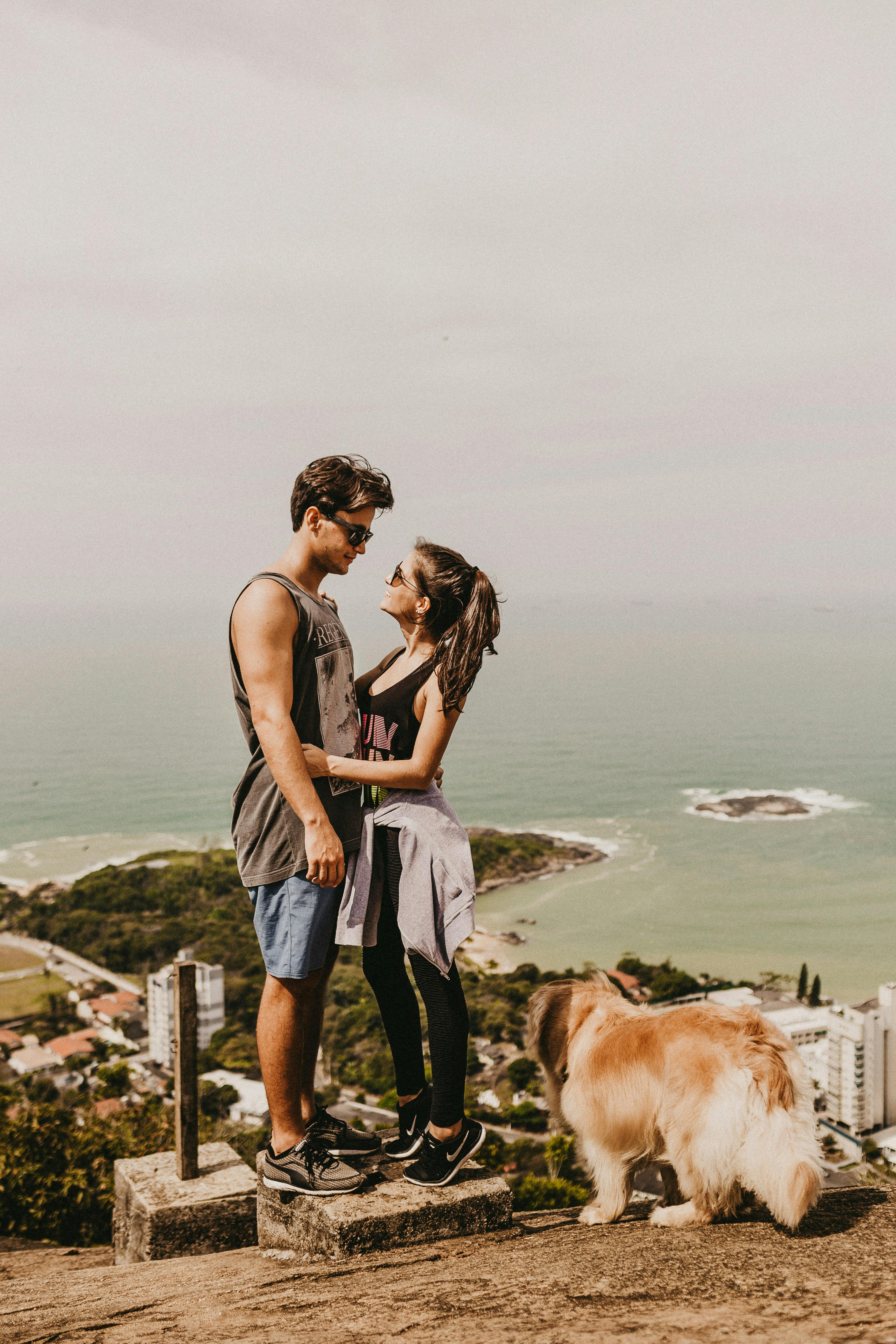 Free A Couple and a Brown Dog Near a Body of Water Stock Photo