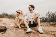 Man Sitting next to his Dog