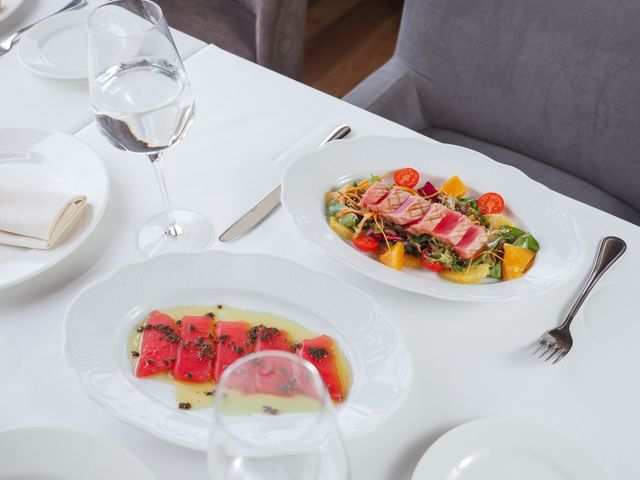 A beautifully plated seafood dish with fresh ingredients on a fine dining table setting.
