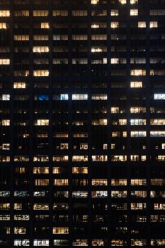 Stunning urban nightscape showing illuminated windows of a high-rise office building.