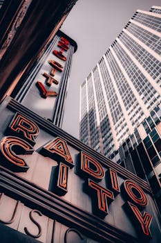 Dynamic view of Radio City Music Hall and modern skyscrapers in New York City.