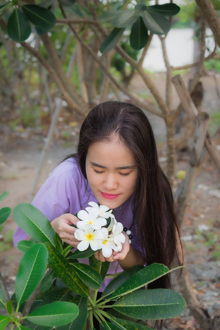 Beautiful Woman Smelling A White Flower