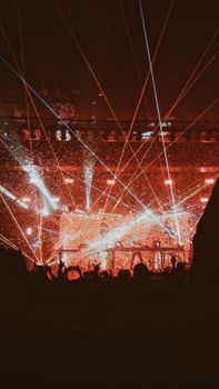 Vibrant concert scene with dynamic light show and audience silhouettes enjoying the night.