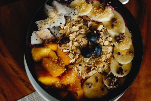 A vibrant breakfast bowl filled with fresh fruits, oats, and granola for a healthy meal.