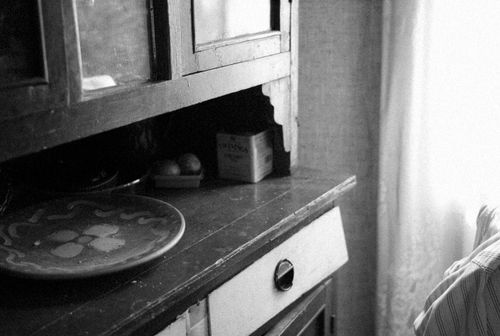 Free A black and white photo of a rustic wooden cabinet with a decorative dish on top. Stock Photo