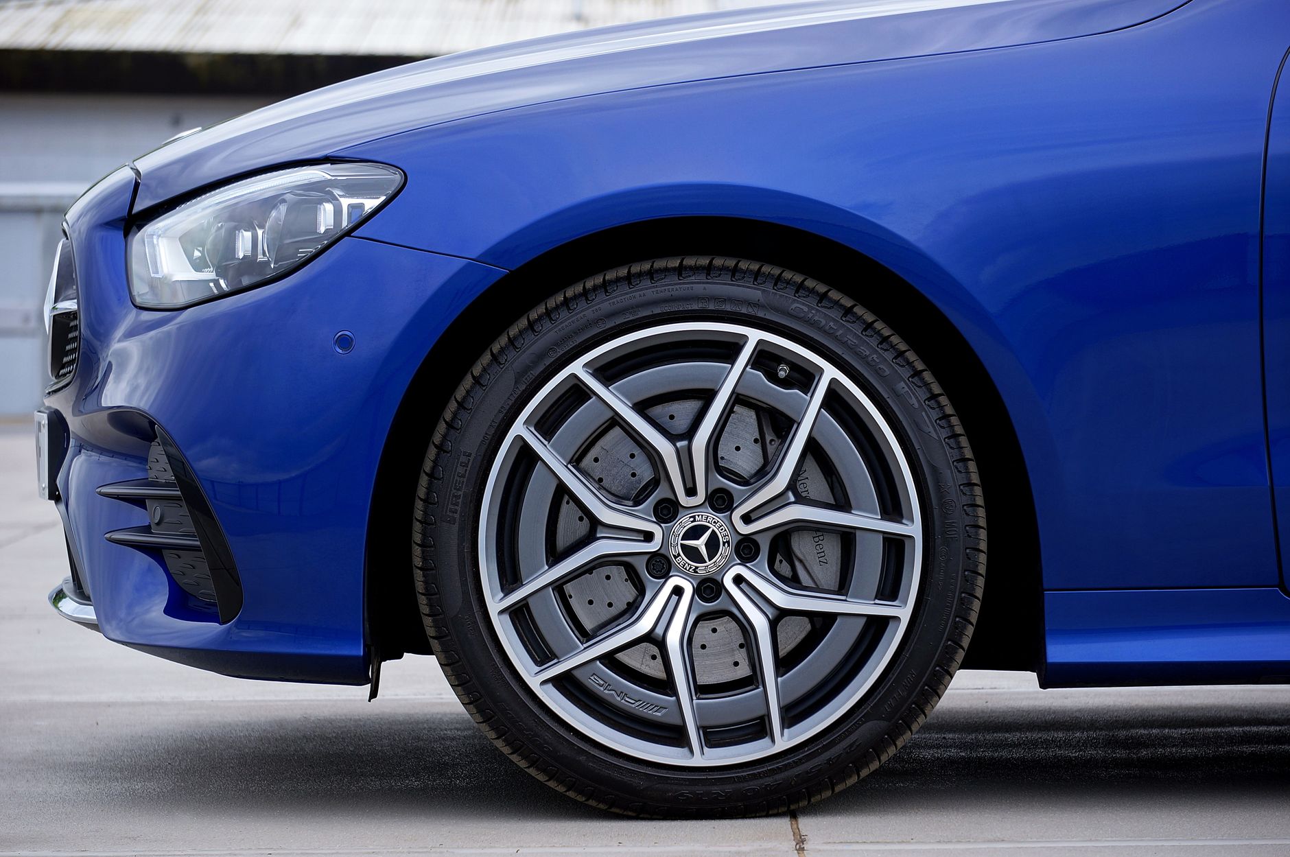 Detailed shot of a blue car's alloy wheel showcasing modern automotive design.