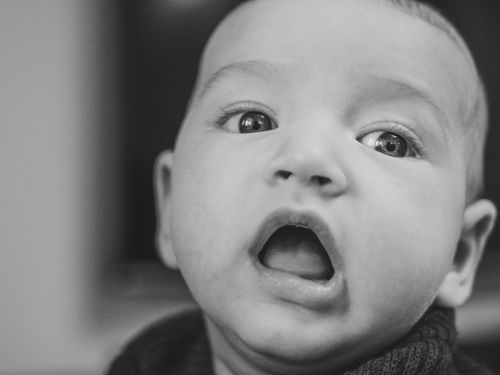 Free Close-up black and white portrait of an expressive baby with open mouth. Stock Photo