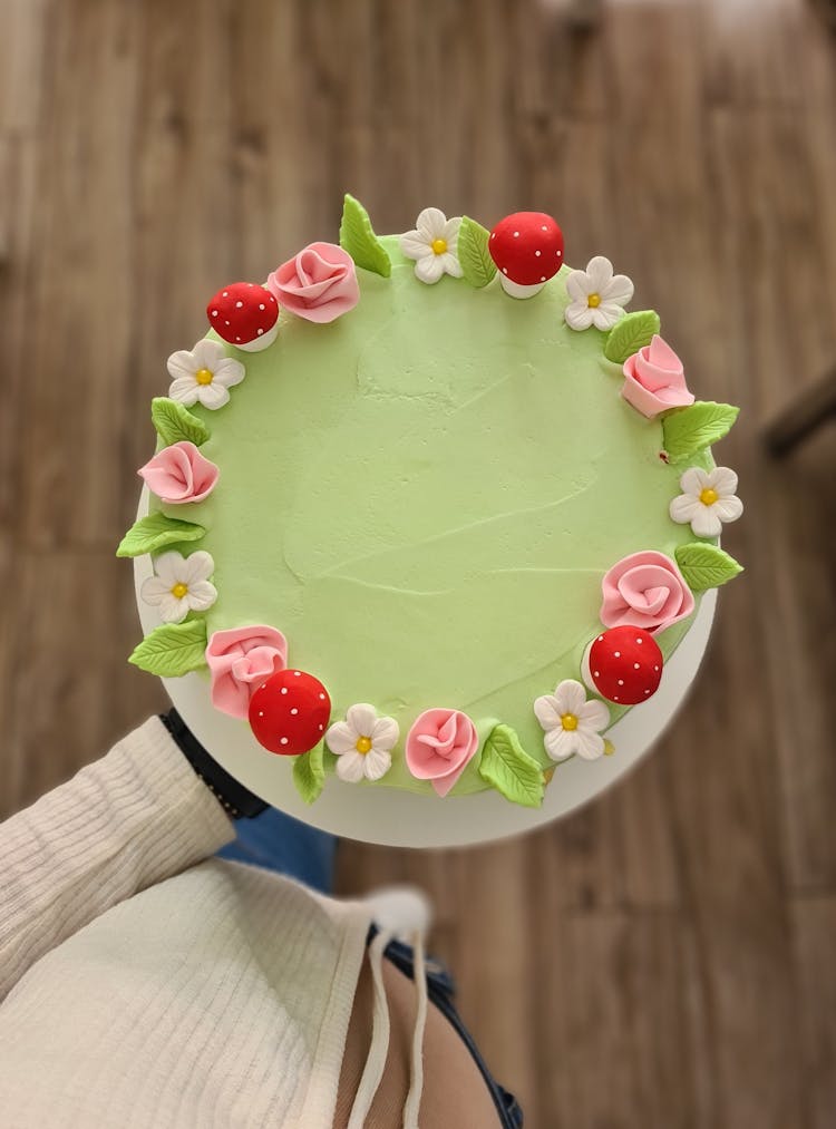 A Cake Decorated With Flowers And Mushrooms