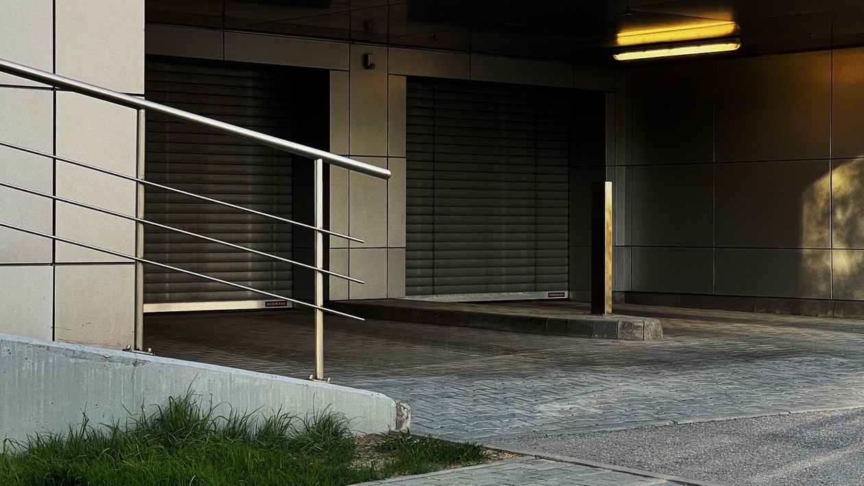 Contemporary building entrance with concrete ramp and metal railing