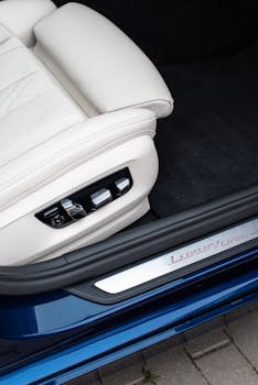 Close-up of a luxury car's white leather seat with adjustment controls and modern design