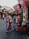 两名身穿彩色和服的妇女漫步在京都的一条传统街道上，展现着日本文化